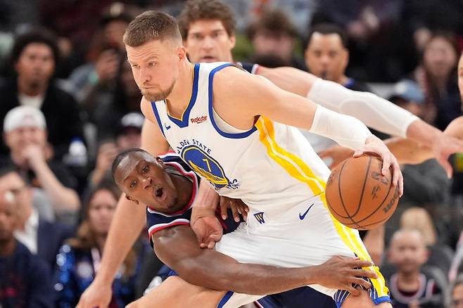 Warriors Clippers BasketballLA Clippers guard Kris Dunn, left, reaches in on Golden State Warriors center Kristaps Porzingis during the second half of an NBA play-in tournament basketball game Wednesday, April 15, 2026, in Inglewood, Calif. (AP Photo/Mark J. Terrill)