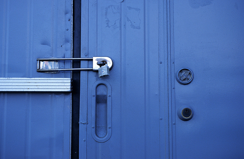 a locked blue gate. Raffiné