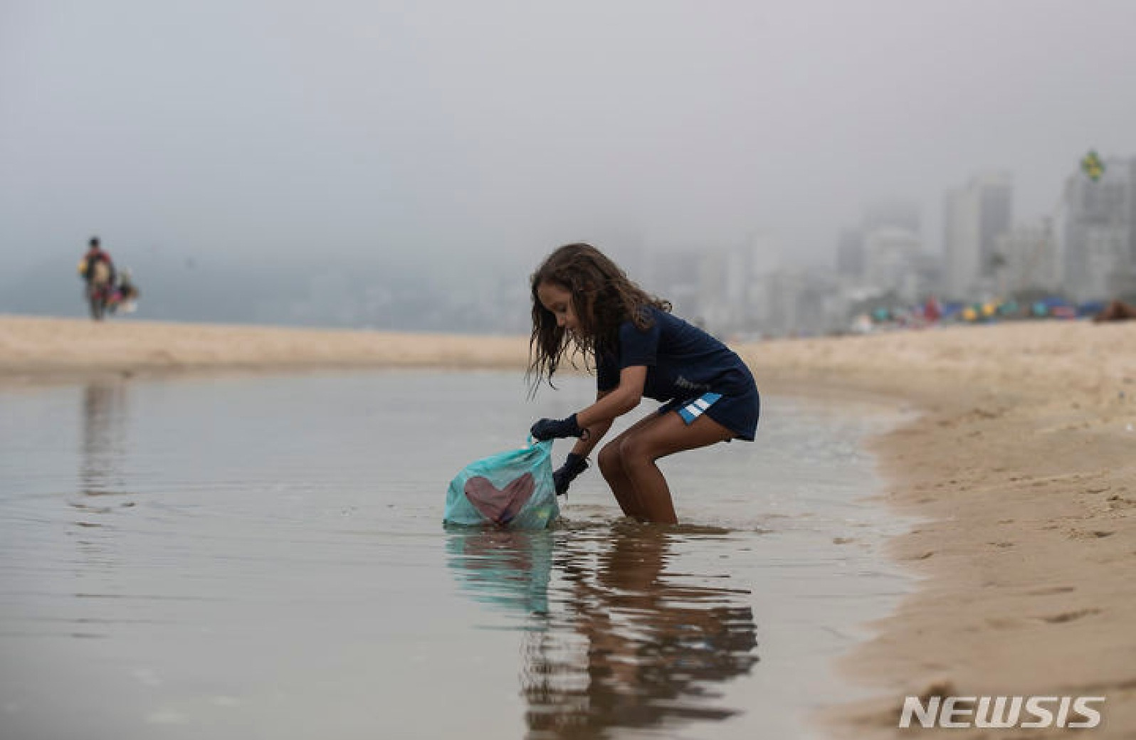 해변 쓰레기 수거하는 브라질 7세 소녀