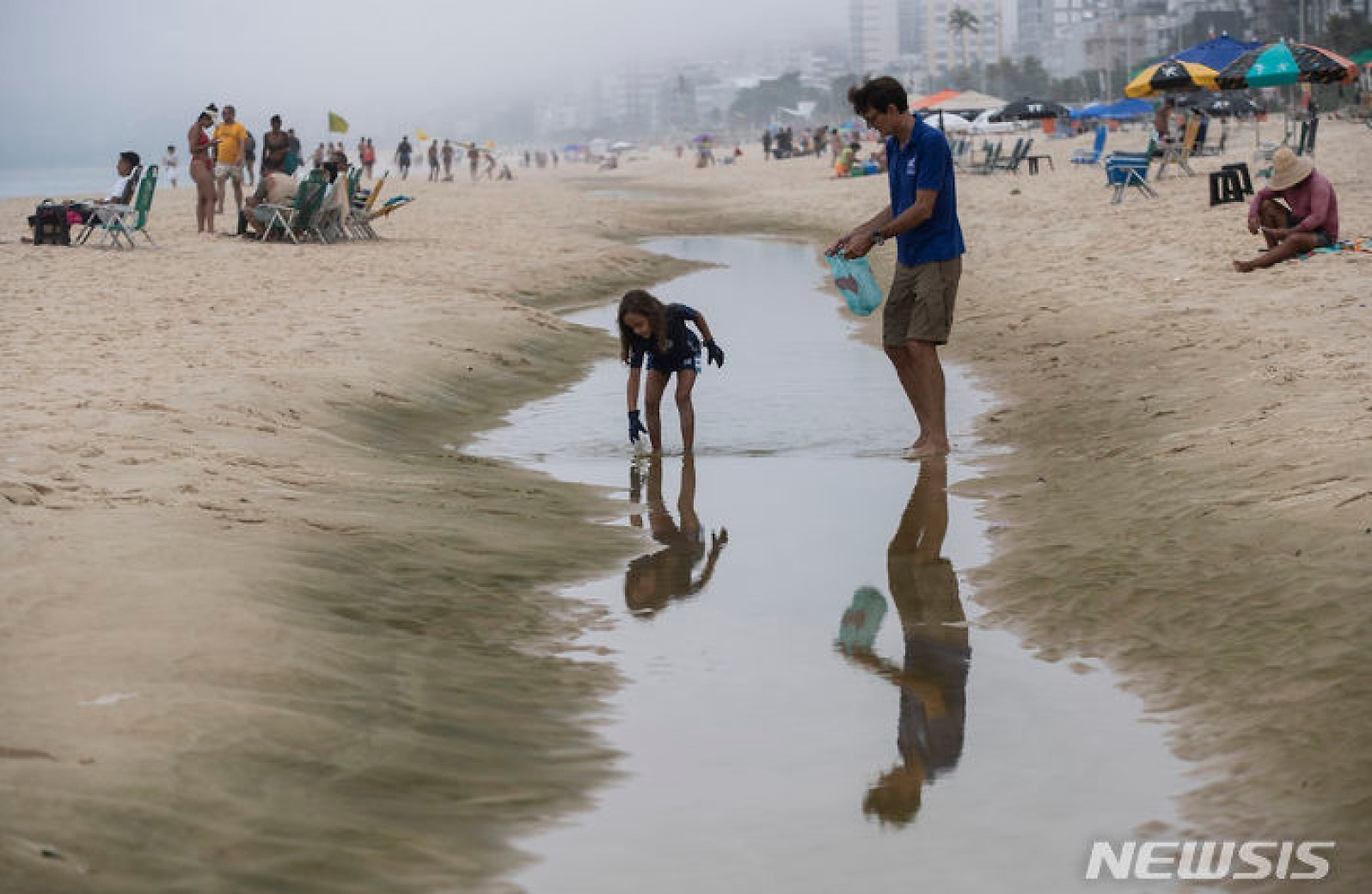 해변 쓰레기 수거하는 브라질 부녀