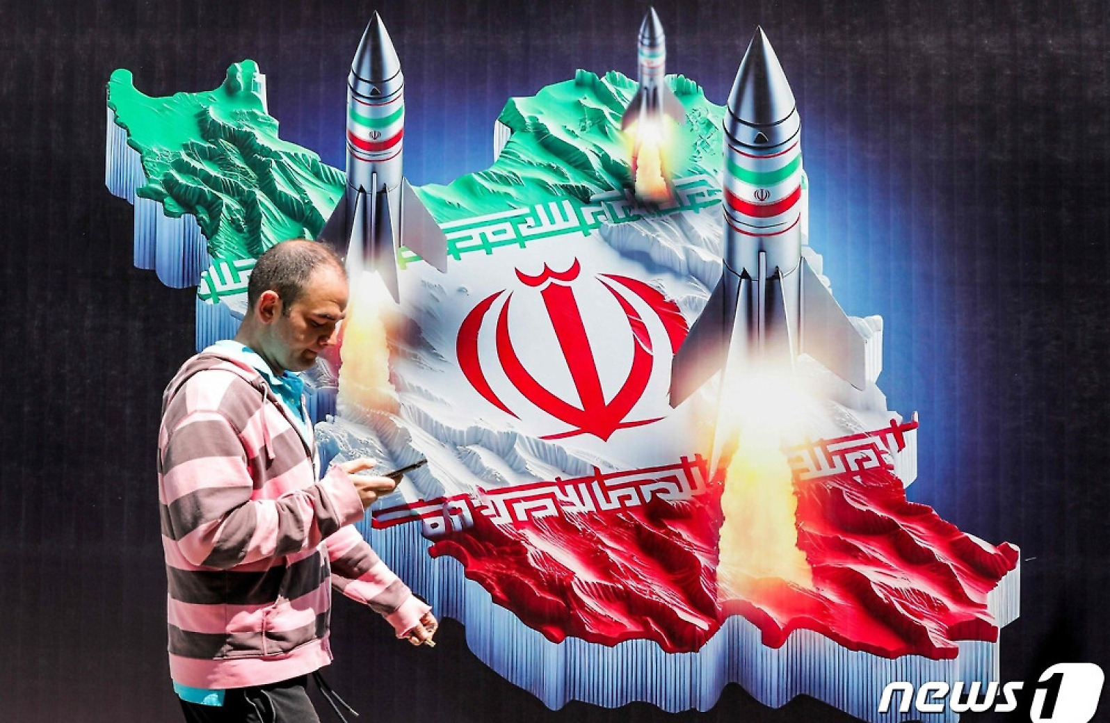 [포토] 이란과 미사일 그려진 벽화 앞 지나가는 남성