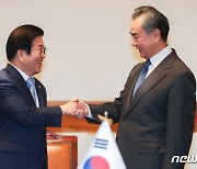 웃으며 악수하는 박병석 국회의장과 왕이 외교부장