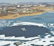 얼어붙은 저수지 위에 떠있는 태양광 발전소