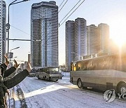 북한 당대회 참가자들 탄 버스에 손 흔드는 주민들