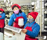 노동신문에 실린 제8차 당 대회 보도 읽는 북한 노동자들