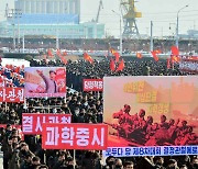 당 대회 결정 '관철' 선전화 들고 행진하는 북한 주민