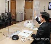 화상 회의에서 손 인사하는 전해철 장관