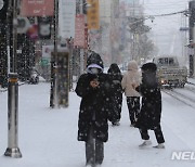 떨어지는 눈 맞으며 걸어가는 시민