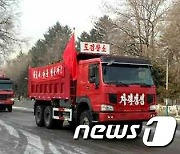 '당 사상관철' '결사 옹위' 거름 싣고 붉은 기 날리는 북한 화물차