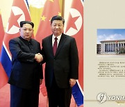 첫 외국방문으로 중국 택한 김정은..시진핑과 악수