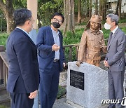 오월 관계자 안내로 5·18시민군 동상 살피는 노재헌