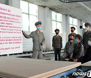 김정은 명언 해설 중인 북한 길주합판공장 노동자들