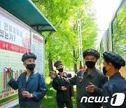 '전투계획' 수행률 기록하는 평양버스공장 노동자들