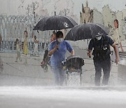 [Photo] Police officer holds umbrellas for mother, child