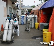 "산소가 부족해요"..산소통 가져오는 인니 의료진