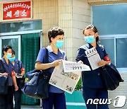 마스크 쓰고..노동신문 전달하는 북한 우편통신원들
