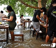 침수된 카페에서 식사 즐기는 태국 사람들