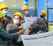 김정은 기념연설 읽고 있는 동평양화력발전소 노동자들