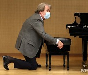 의자 높이 조절하는 피아니스트 루돌프 부흐빈더