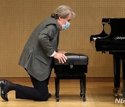 의자 높이 조절하는 피아니스트 루돌프 부흐빈더