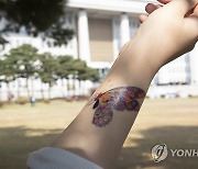 타투 스티커 보여주는 시민