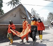 화산 폭발 희생자 옮기는 인도네시아 구조대