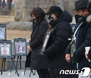 '가족 영정 사진 들고'