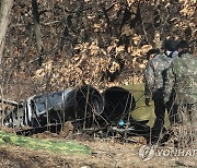 추락 전투기 동체 살펴보는 군 관계자들