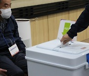 사전투표 첫날, 투표 용지 넣는 유권자