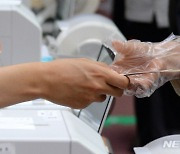 '비닐장갑 착용하고 투표권 받는 유권자'
