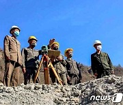 양강도 수력발전소 건설 현장을 살펴보고 있는 북한 일꾼들