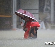 폭우로 물에 잠긴 도로 어린이 안고 걷는 방글라 주민