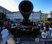 러시아 침공군 무기 살피는 키이우 시민들