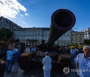 러시아 침공군 무기 살피는 키이우 시민들