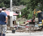 산사태로 무너져버린 집 복구작업 바라보는 주민들