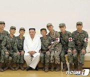 인민군 군의관들과 기념 촬영하는 김정은 위원장