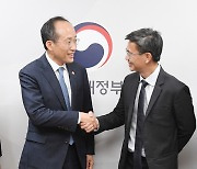 킴엔 탐 선임이사와 악수하는 추경호 부총리