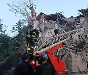 러 공습으로 파괴된 건물서 작업하는 소방대원들