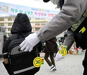 어린이 가방에 교통안전 고리 달아주는 경찰관