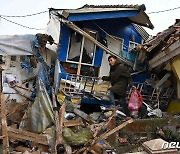 인니 지진…주저 앉은 가옥에서 물품 찾기