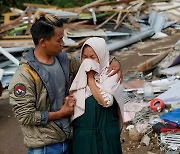 지진으로 무너진 집 앞에서 울고 있는 여성