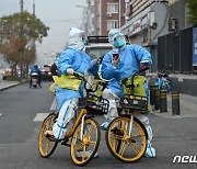 자전거로 방역용품 옮기는 보건 당국자들
