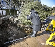 상수도관 파열 현장에서 누수 의심 현장 확인하는 관계자