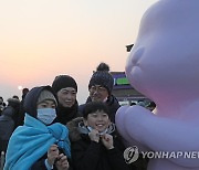 토끼 조형물에서 사진 찍는 가족