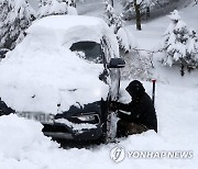 폭설에 묻힌 차 빼내는 운전자