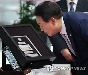 바라카 원전 방문시 양국 정상 교환 기념물 보는 윤석열 대통령