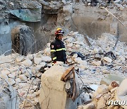 콘크리트 더미 위 망연자실한 시리아 구조대원