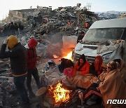 [포토] 잔해 옆 모닥불로 추위 달래는 강진 생존자들