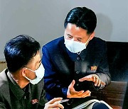 인공기·국장 앞에서 토의하는 북한 공장 지배인과 초급당 비서