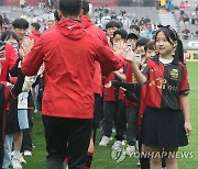 축구선수들과 하이파이브하는 어린이들